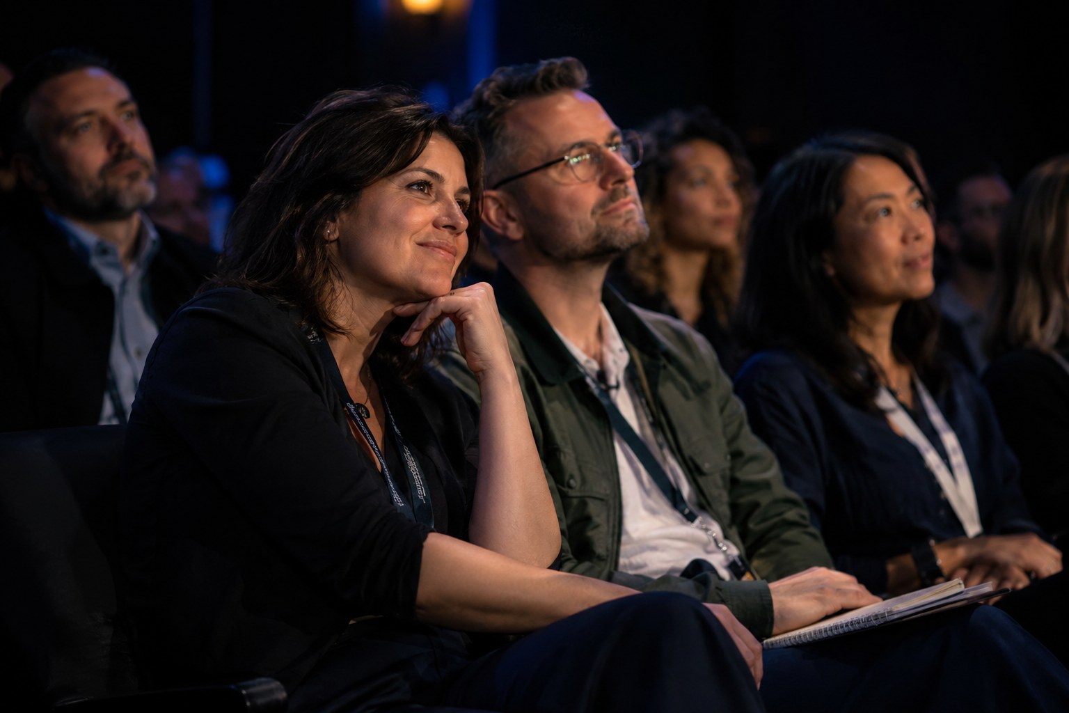 Audience members leaning in and listening during a talk
